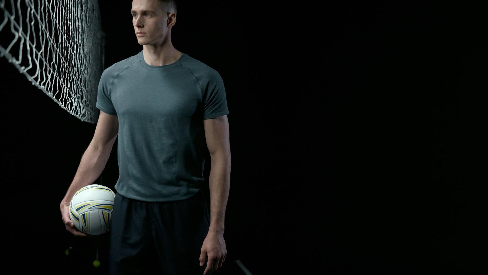 Athletic person moving in a dark studio with golden light