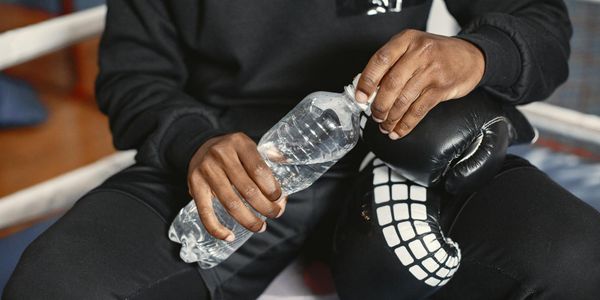 Person hands holding a water bottle during break